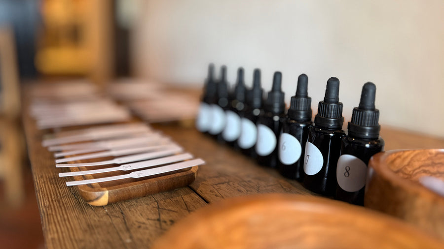 Frascos de esencias aromáticas numerados y tiras olfativas dispuestas sobre soportes de madera durante el taller El lenguaje de los aromas en Pedraza, Segovia.