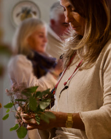 Pequeño grupo de participantes creando coronas florales en un entorno tranquilo durante un taller en Pedraza.
