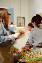 Participantes creando sus coronas florales durante el taller en Pedraza