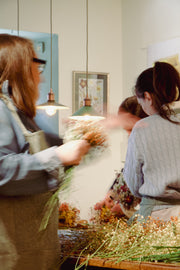 Participantes creando sus coronas florales durante el taller en Pedraza